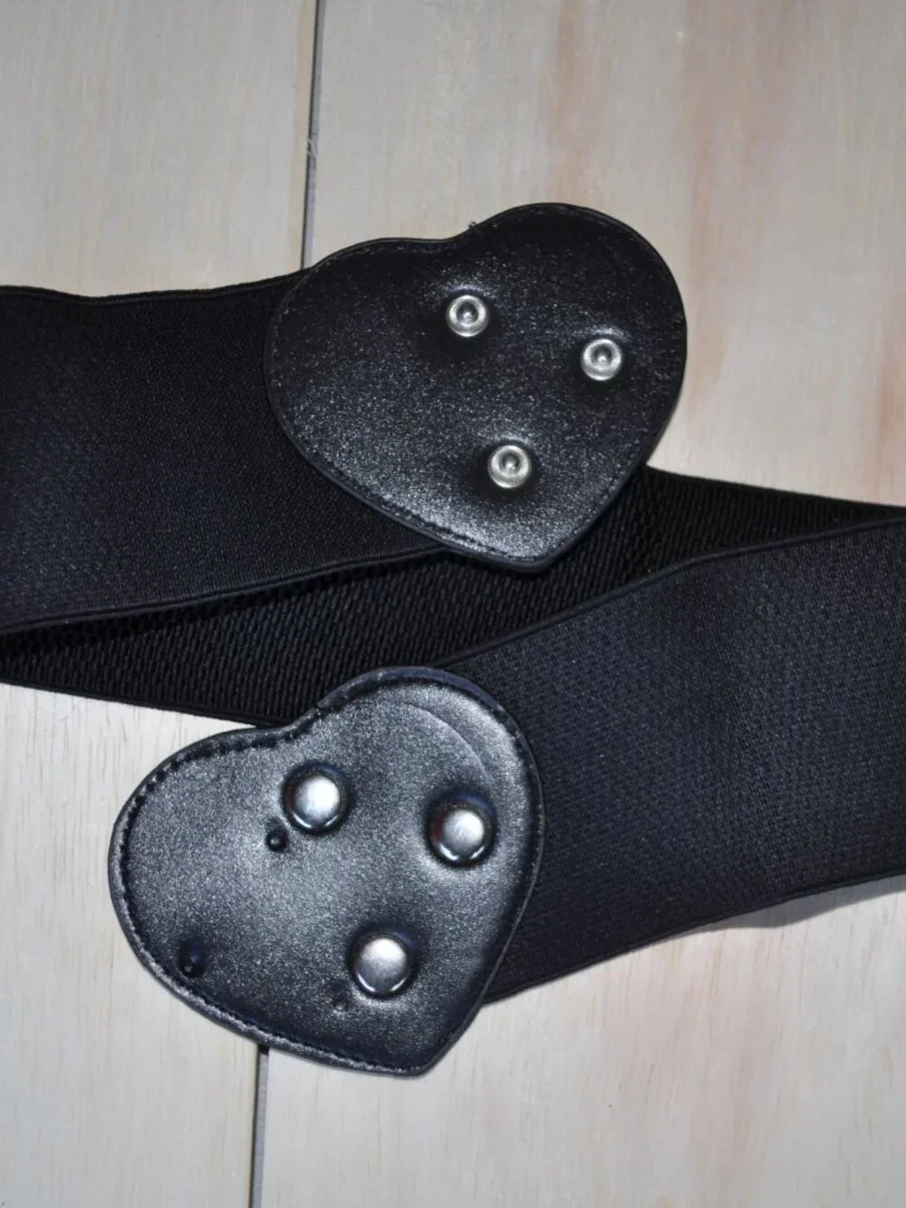 women's black elastic waistband belt features a distinct faux leather heart-shap